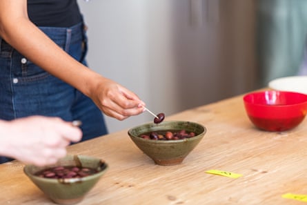 Taster picks out a kalamata olive from a bowl