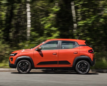 A red Dacia Spring driving on a country ride