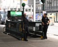 Two police officers at the top of a sidewalk-level subway entrance.