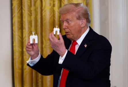 Donald Trump holds models of an arch