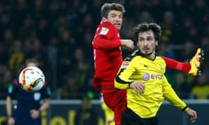 Bayern Munich’s Thomas Müller and Borussia Dortmund’s Mats Hummels challenge for the ball.