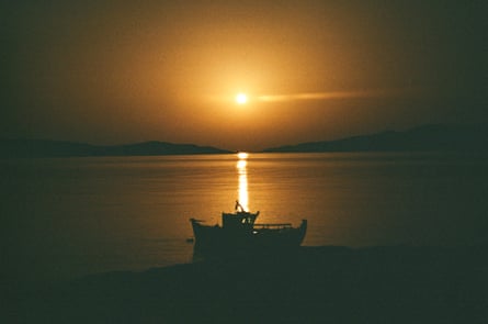 A fishing boat silhouetted by the sun 