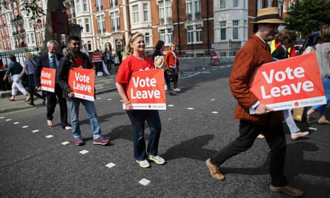 Vote Leave supporters holding banners cross the road outside the Chelsea flower show in London.