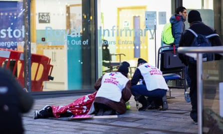 Striking nurses treat a passerby who slipped over outside Bristol Royal infirmary.