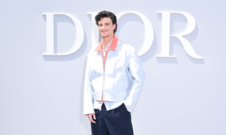 Adam DiMarco posing in front of Dior sign