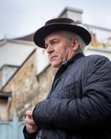Jean-Claude Cintas in black jacket and brown felt hat with a feather