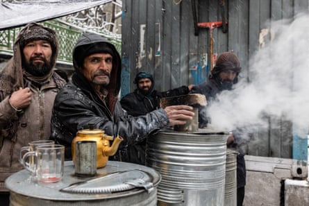 Tea vendors warm their hands on a cold day in Kabul