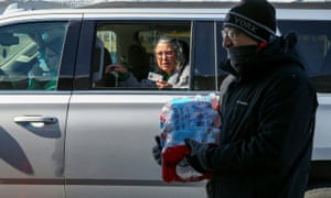 Volunteers hand out cases of water bottles at the Schlitterbahn Waterpark parking lot in Galveston, Texas.