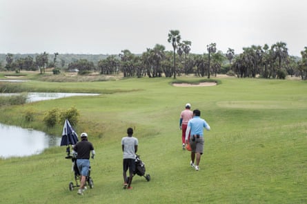 Young men from the local area work as caddies at the Mangais golf resort