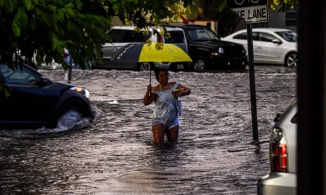 A woman walks in flooded water in Miami, Florida. - 