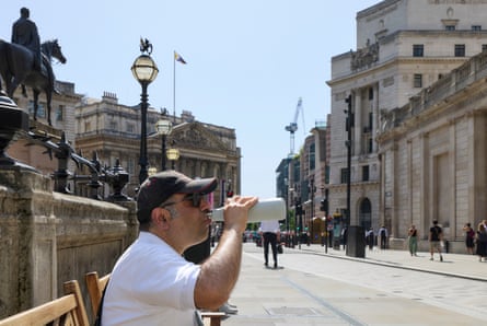 A man drinks from a water bottle in the City of London.