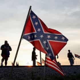 trump supporters stand near confederate and US flags