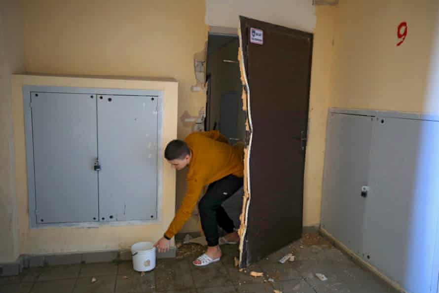 A man is seen in the corridor of a damaged apartment block after shelling in Kharkiv.