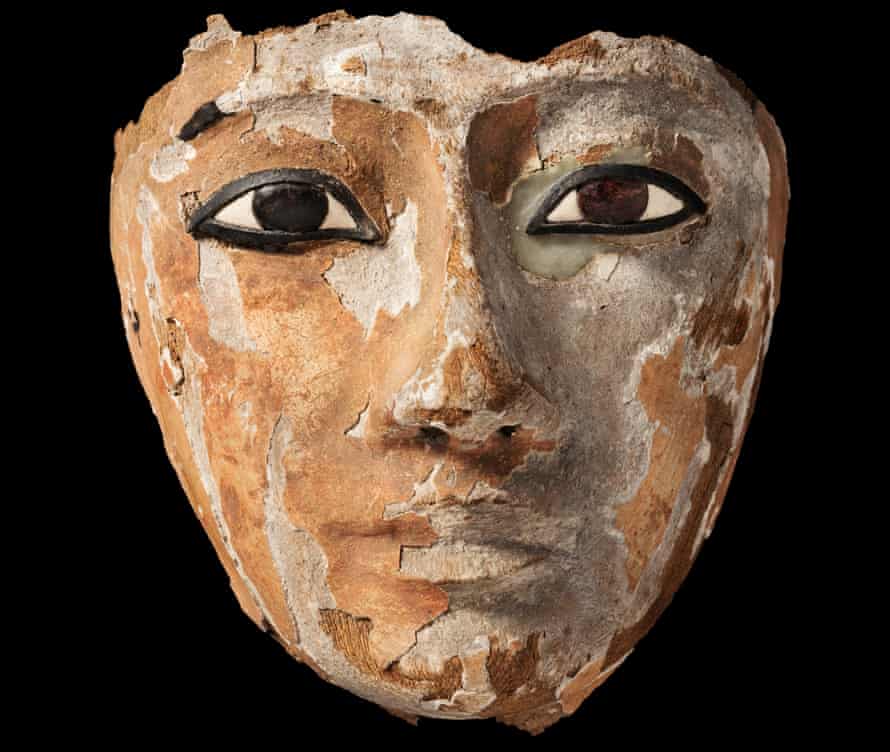 An Egyptian wooden face with inlaid eyes, originally part of a coffin.