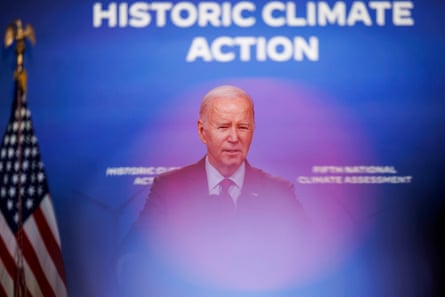 A man speaks in front of a backdrop that reads "historic climate action"