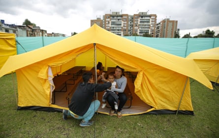 A Venezuelan migrant family inside a tent full of cots at the new camp in Bogotá