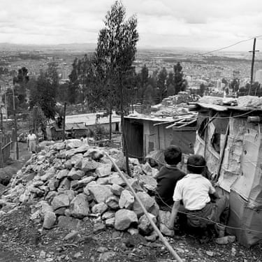 Construcción de una nueva casa (Building a new house) A family looking out over the barrio, Luis Alberto Vega, towards Bogotá. The barrio was named after the man who was killed by police in a shooting on Easter Sunday (1966). He was one of the men who helped set up the house for Alicia. “By one-thirty on Easter Sunday, when the police showed up, we were ready.” Alicia (page 109)//“A family looking out over the barrio, Luis Alberto Vega, towards Bogotá.The barrio was named after a man killed by police in a shooting on EasterSunday, 1966.”