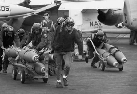 US navy armorers wheel out 500lb bombs for the wing racks of jets being used in support for South Vietnamese troops in Laos in 1971.