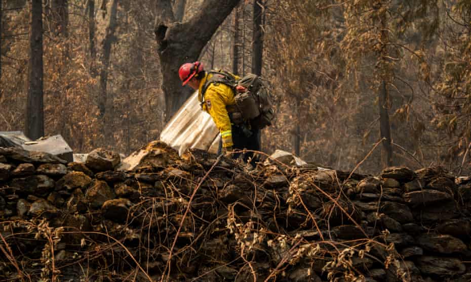 Fire Capt Chase Beckman inspects a structure destroyed by the Dixie fire, looking for clues about the construction, on Saturday.