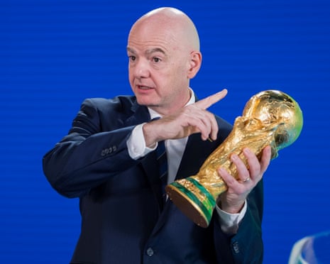 The FIFA president, Gianni Infantino, holds the World Cup trophy during the 2026 play-offs draw.