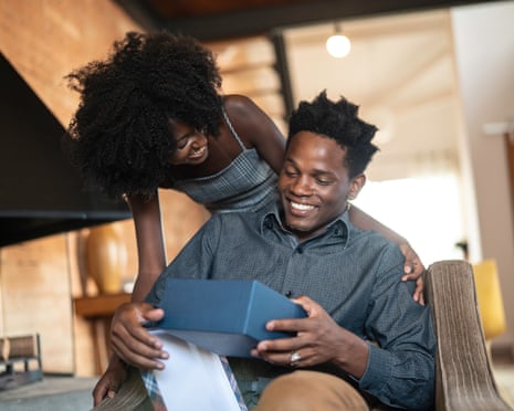 A woman giving a gift to a man