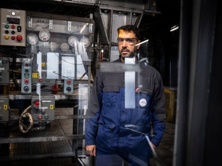 Suliman El Moussaoui stands next to machinery.