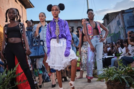 A group of women wearing bright and eclectic clothing pose.