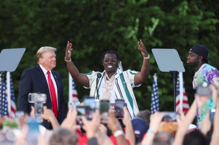 Donald Trump watches as rappers Sheff G and Sleepy Hallow join him on stage at a campaign rally at Crotona Park in the Bronx, New York