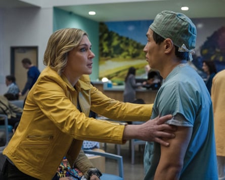 Rhea Seehorn grabs a hospital staffer by the arms, looking agitated - he is blank