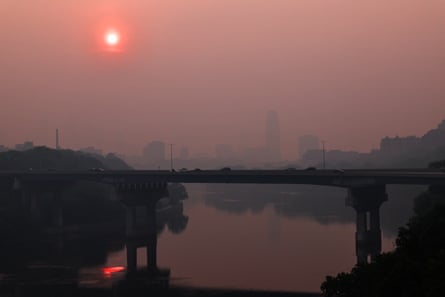a hazy red skyline near a bridge
