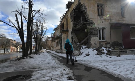 A local resident walks past a heavily damaged building in Izyum, Ukraine, on 20 February.