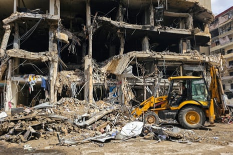 A bulldozer clears rubble from a street at the site of an Israeli airstrike in Beirut’s southern suburbs.