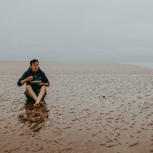 Author Patrick Barkham sat on a sandbank off the north Norfolk coast eating his lunch.