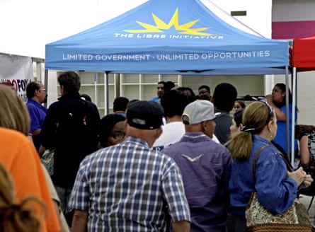 A group of people line up outside a tent for The Libre Initiative