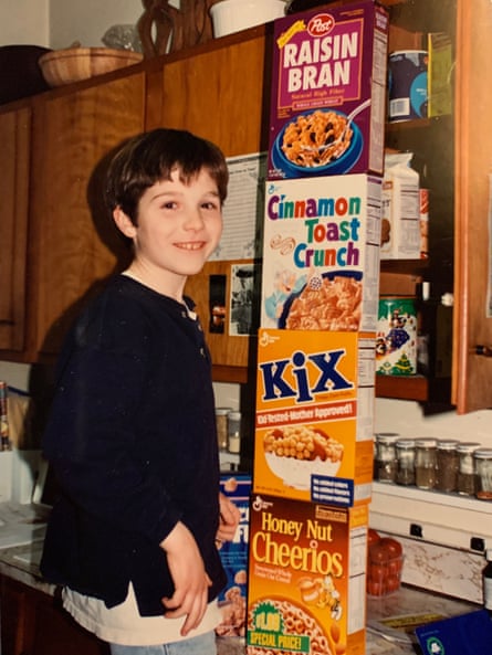 photograph of child next to four cartons of cereal