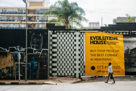 A pedestrian passes by a residential construction project in Maboneng.