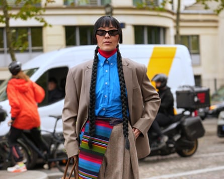 Street Style Paris fashion week womenswear Spring Summer 2026 Day EightLayering with pop of colour, red rollneck under blue shirt for 50 autumn fashion updates. PARIS, FRANCE 06 OCTOBER: A guest wears centre-parted long black hair styled in two long braids with blunt bangs, black cat-eye sunglasses, brown suede top-handle bag with a gold zipper, red turtleneck layered under a bright blue cotton button-down shirt, oversized taupe wool blazer jacket, multicoloured striped woven sash wrapped at the waist over high-waisted brown tweed wide-leg trousers, black leather ankle boots with low heel, outside Miu Miu, during Paris fashion week womenswear Spring Summer 2026, on 06 October 2025 in Paris, France (Photo by Edward Berthelot/Getty Images)