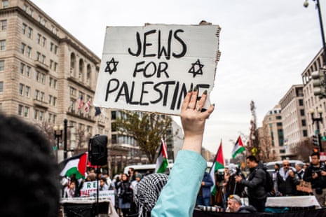 A person holds a sign that reads "Jews for Palestine"
