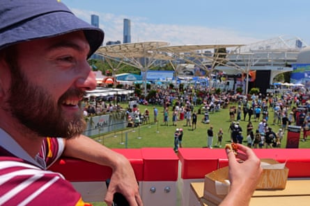 A view past a man eating of crowds on the lawns at Melbourne Park below