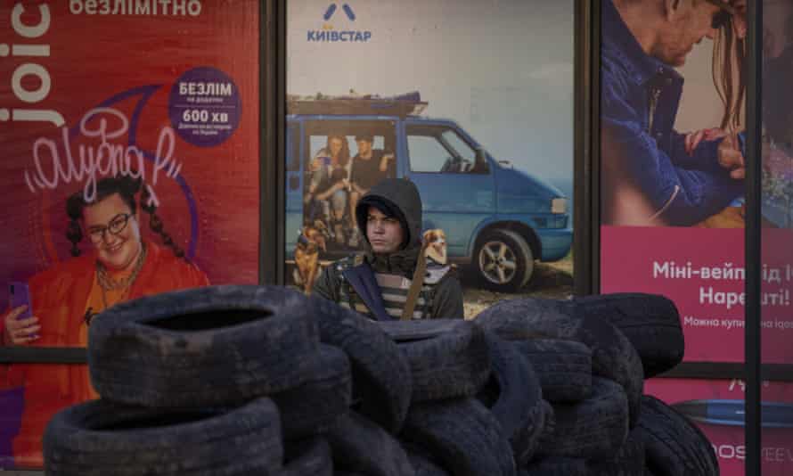 A civil defence man stands guard at a checkpoint in Kyiv on Saturday.
