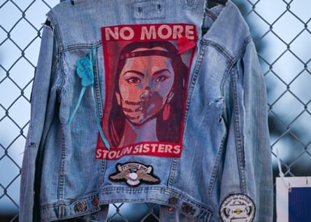 A denim jacket attached to a fence with a patch that reads ‘No more stolen sisters’