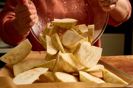 wedges of celeriac being dumped out of bowl on to a tray