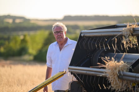 Jeremy Clarkson standing in a field behind farm machinery