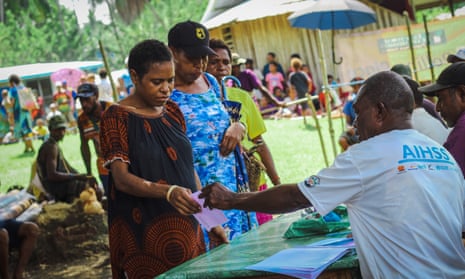 Women receive their ballot papers at a polling area in Madang.