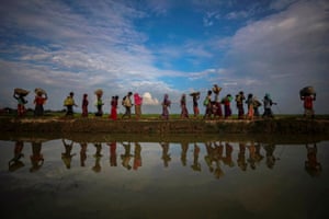 Rohingya refugees are reflected in rain water along an embankment next to paddy fields after fleeing from Myanmar into Palang Khali, near Cox’s Bazar, Bangladesh, 2 November, 2017. Hundreds of thousands of Rohingya in the northern part of Rakhine State fled, seeking sanctuary in Bangladesh. Reuters photographers were first to reach the area. They followed people through neck-deep waterm their feet wrapped in duct tape against leeches. “I had a few moments where my heart outweighed my head and I had to stopshooting to help the people in front of me,” said Hannah McKay