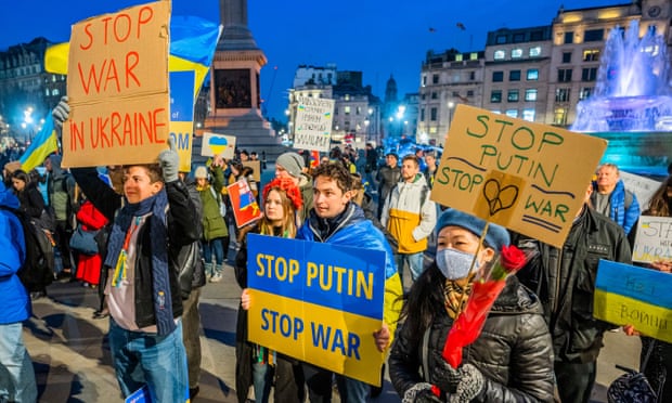Protesters in Trafalgar Square, London, with signs reading "Stop war in Ukraine" and "Stop Putin, stop war"