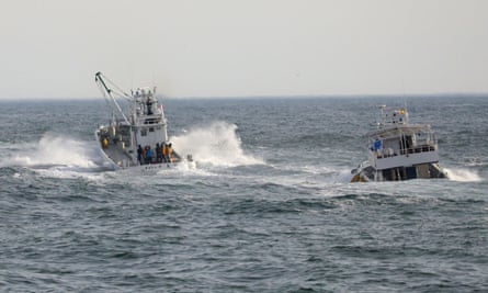 Fishing boats conduct a search operation for missing people on Sunday.