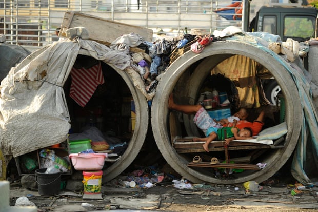 Families live in concrete pipes used as makeshift dwellings along a street in Manila. A quarter of the nation’s 100 million people live in poverty.