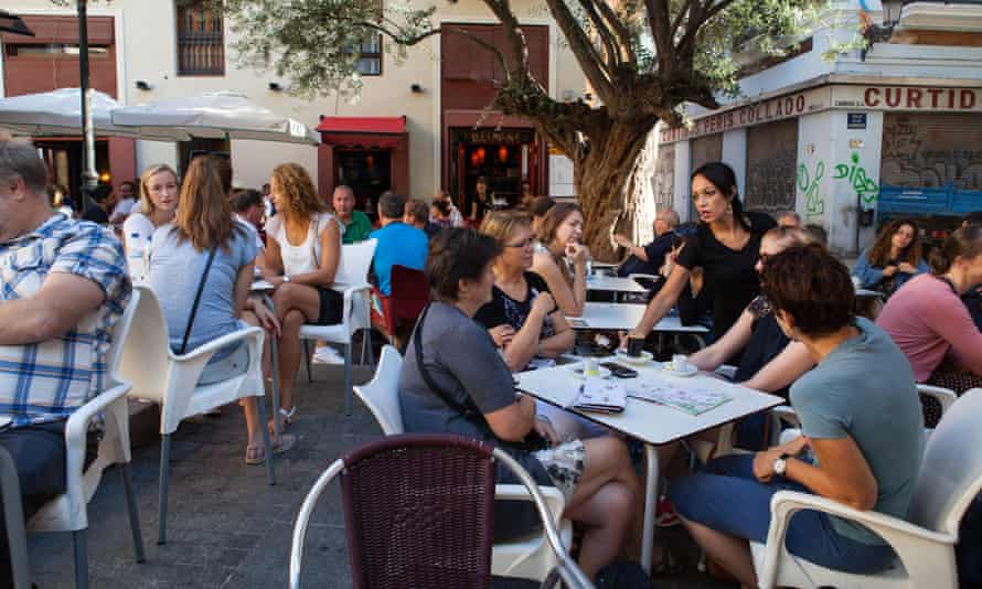 Personal y clientes en una cafetería y bar de tapas en el casco antiguo de Valencia
