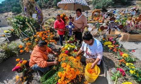 People decorate a relative’s grave prior to the Day of the Dead at the Municipal Pantheon in Valle de Chalco, Mexico.